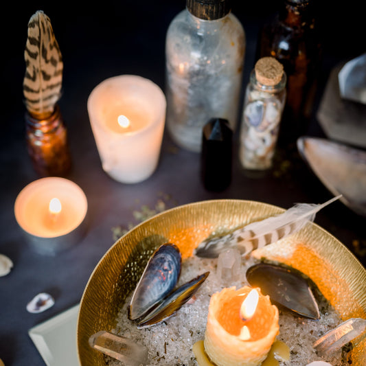 An altar with candles, shells and feathers