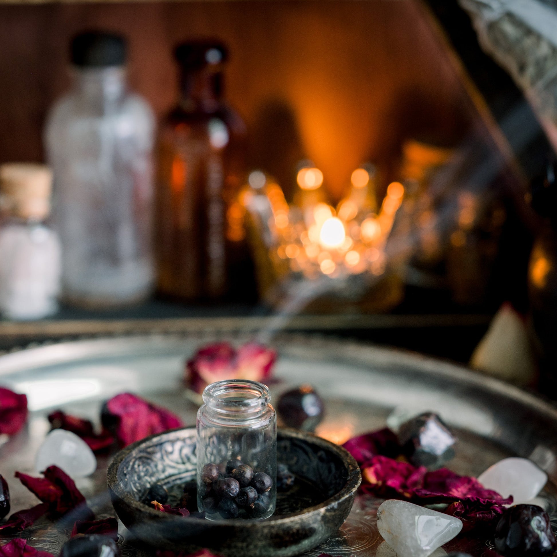 Insence burning in a charcol burner on a altar. Candles are in the background.