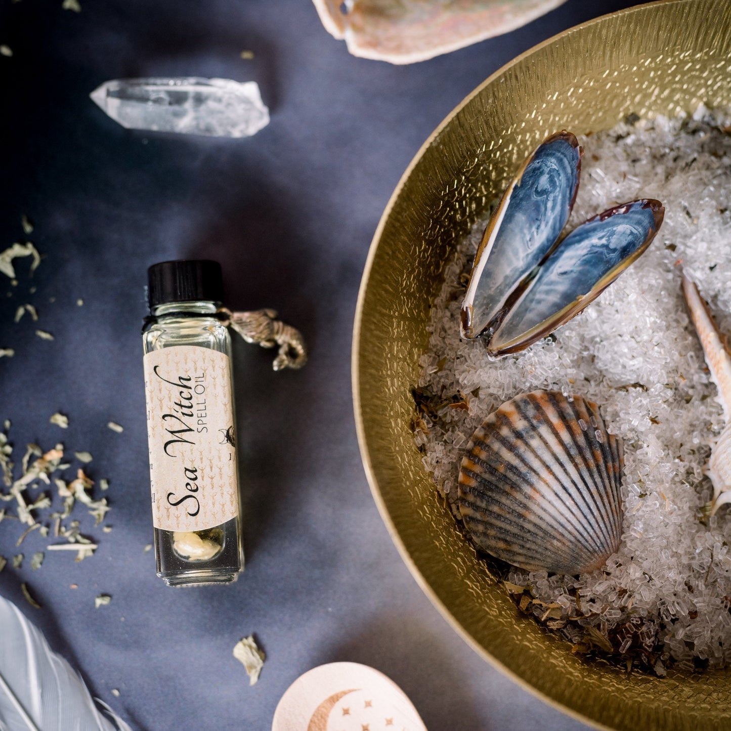 An altar with sea shells, feathers, crystals and a potion.
